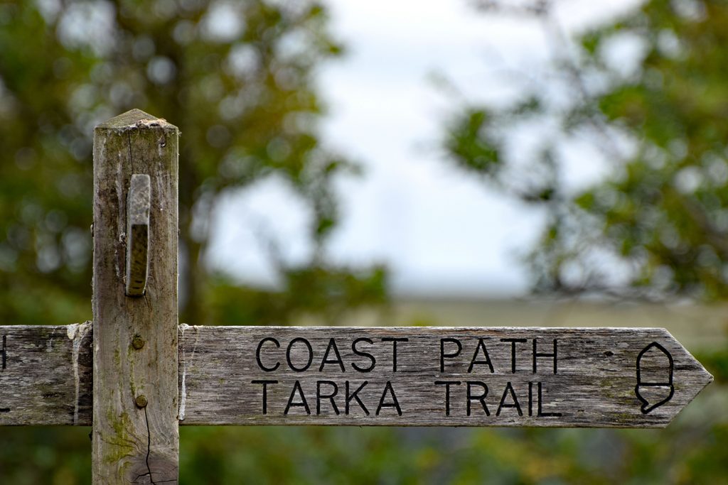 A wooden sign on the Southwest Coast Path / Tarka Trail public footpath and cycleway. Taken between Bideford and Barnstaple in North Devon England		