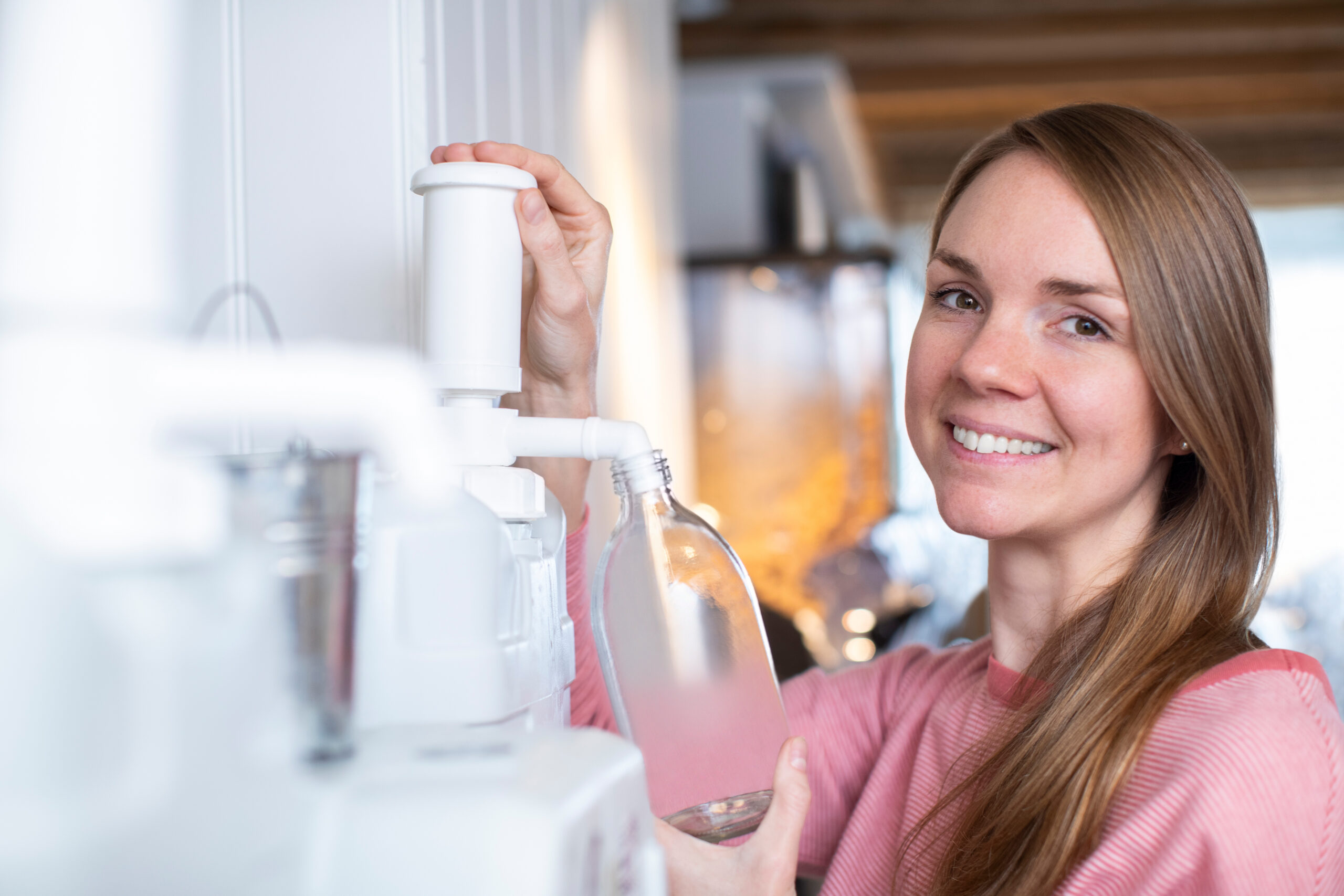 5 Sustainable Household Swaps to Make Today. A Woman Filling a Container With Cleaning Product In Plastic Free Grocery Store