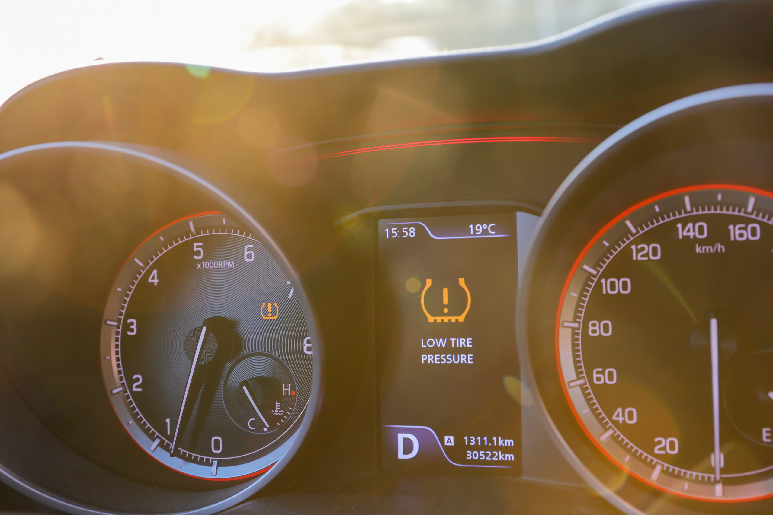 Low tire pressure error sign. Warning lights flash on the car dashboard.