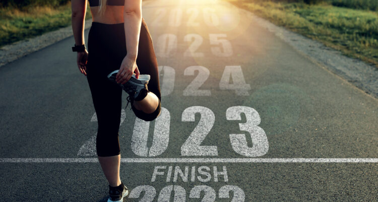 Woman stands at the finish line of 2022 and gives a new start to 2023