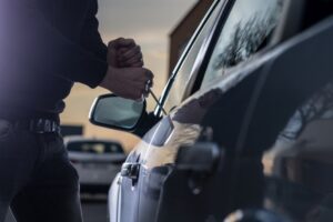 A man breaking into a car 