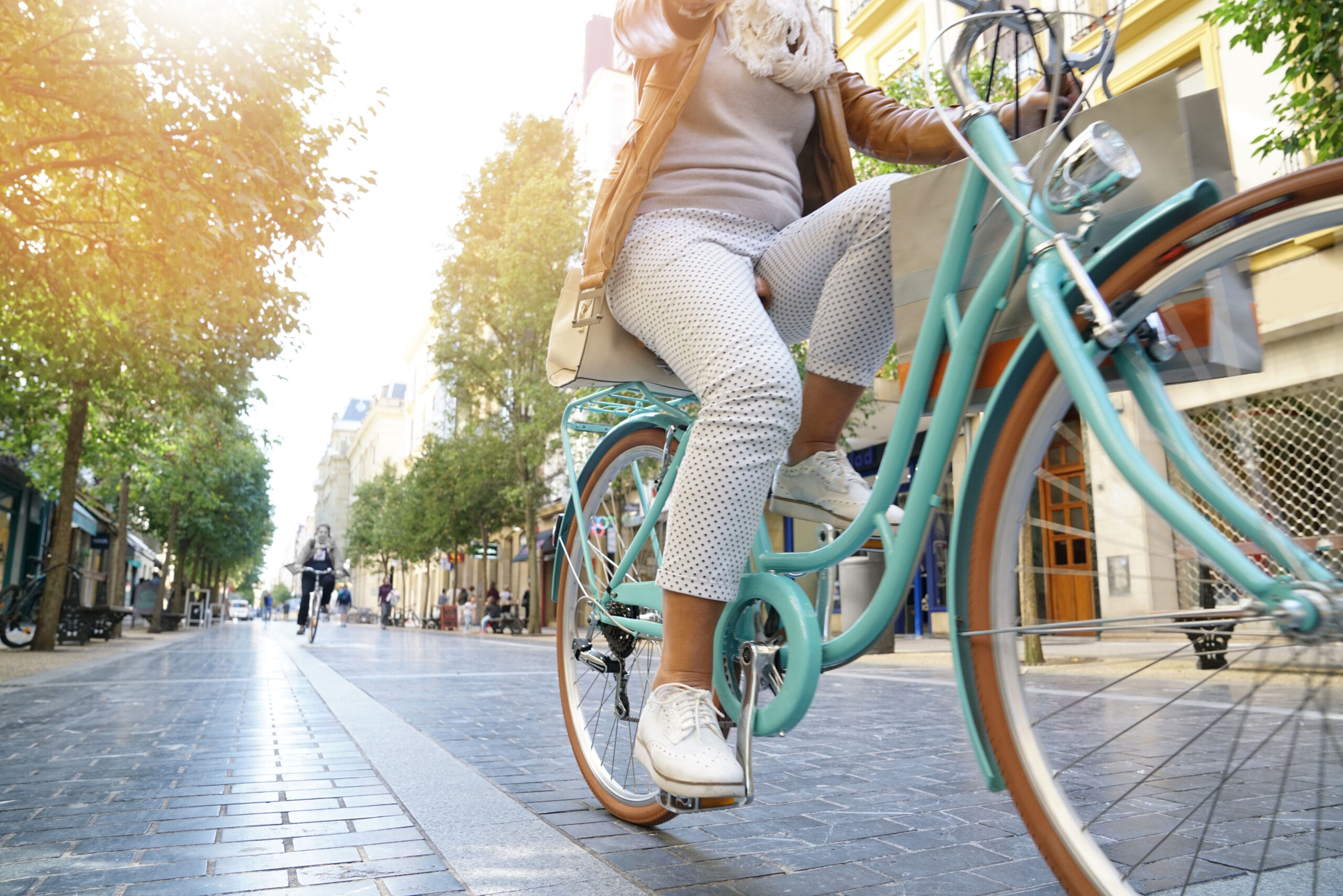 Women riding a pastel blue city bike through town