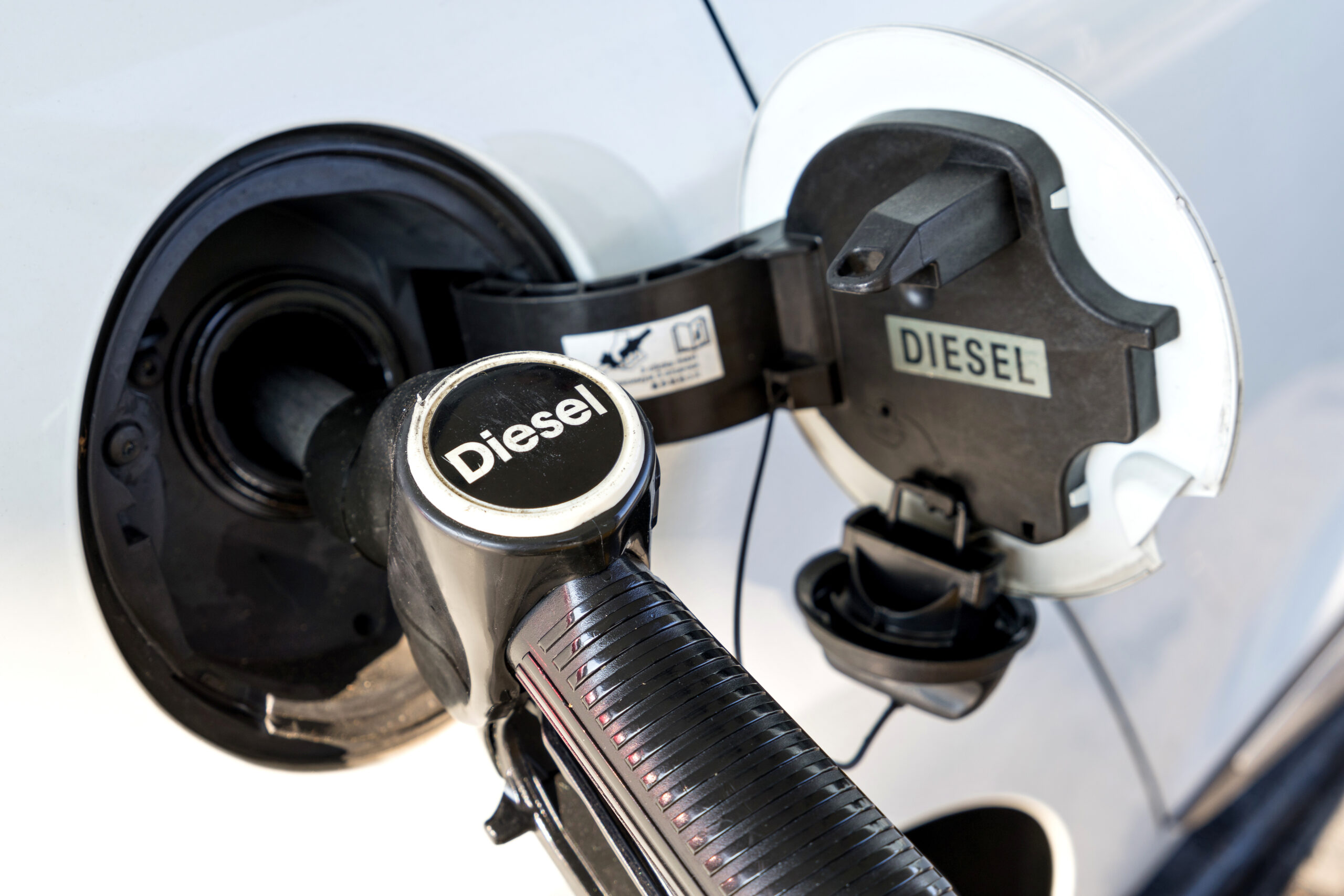 A black diesel pump, fueling a car