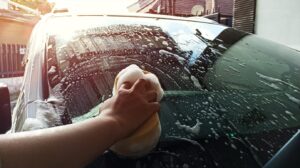 Man washing car windscreen with sponge