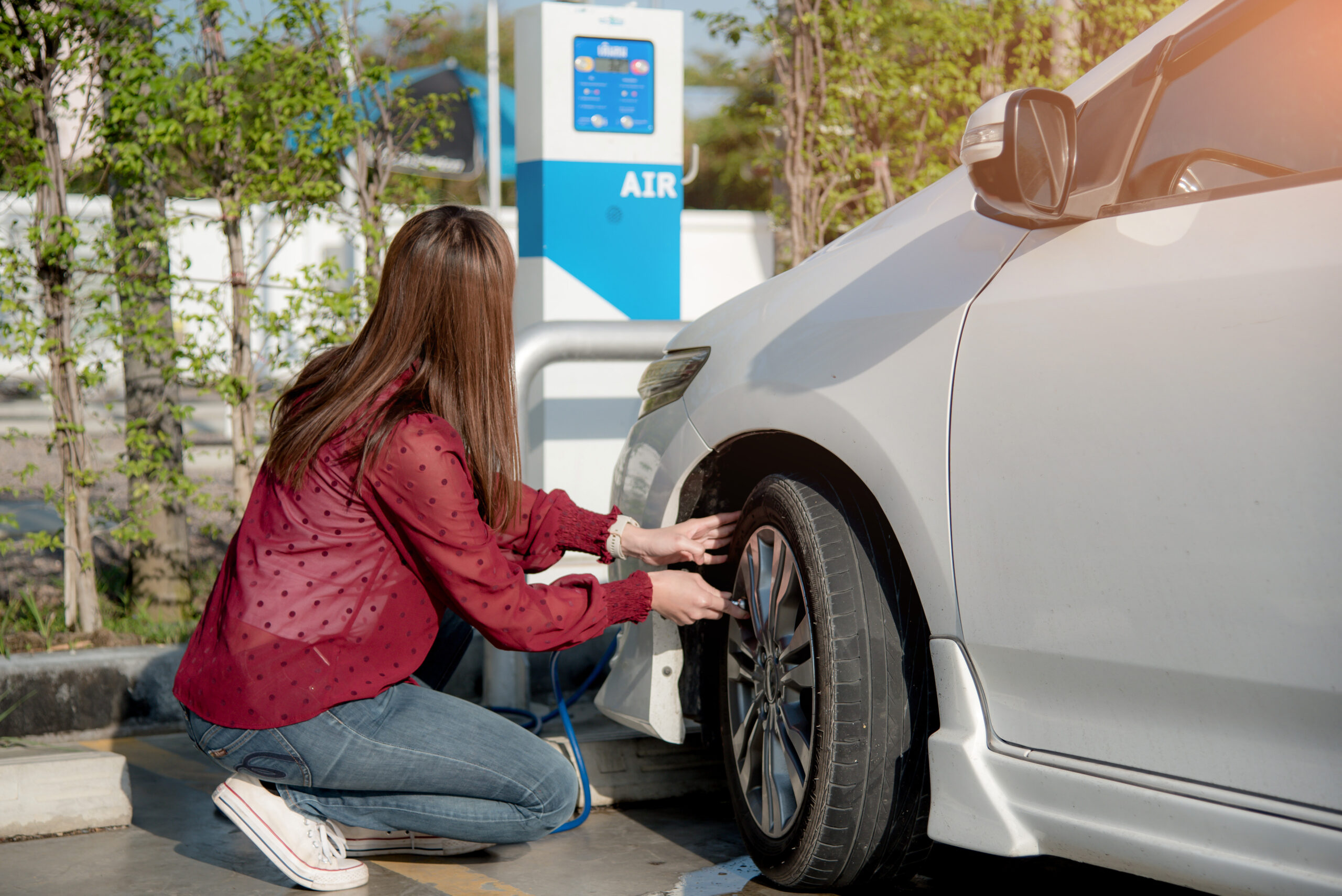 Woman adding air to her car tyres 