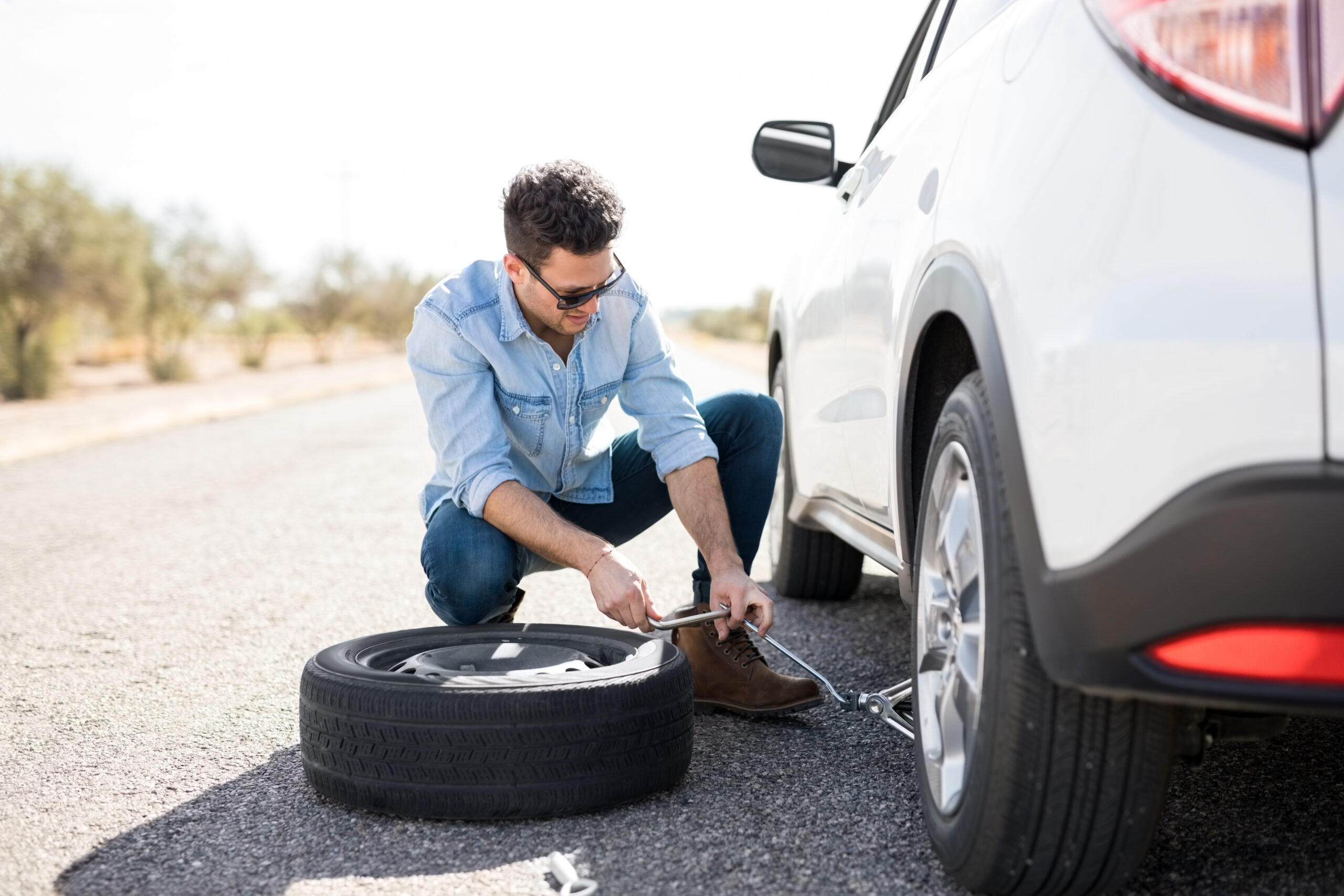 Man jacking up the car to change tyre