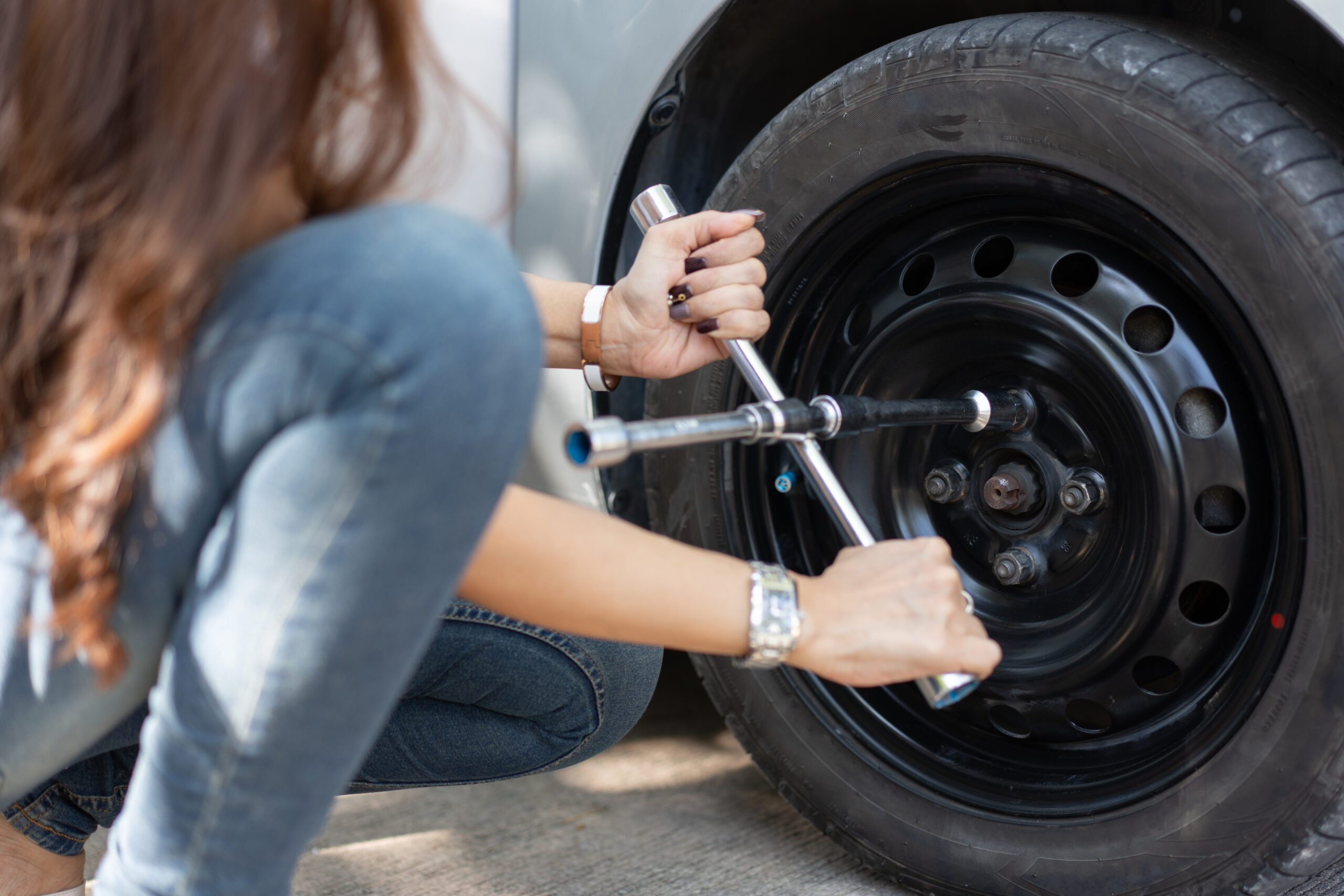 Woman checking lug nuts 