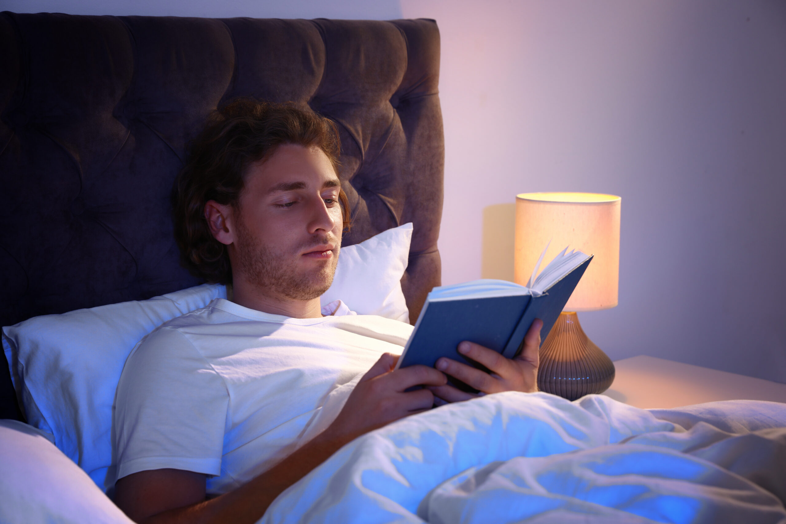 Man reading his book in bed
