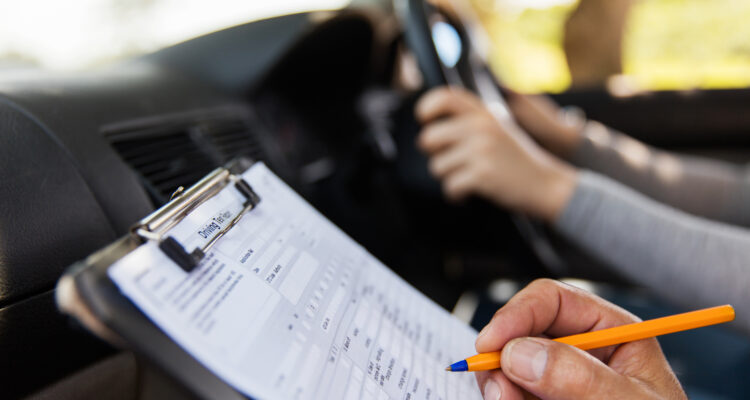 Driving Examiner testing student in car